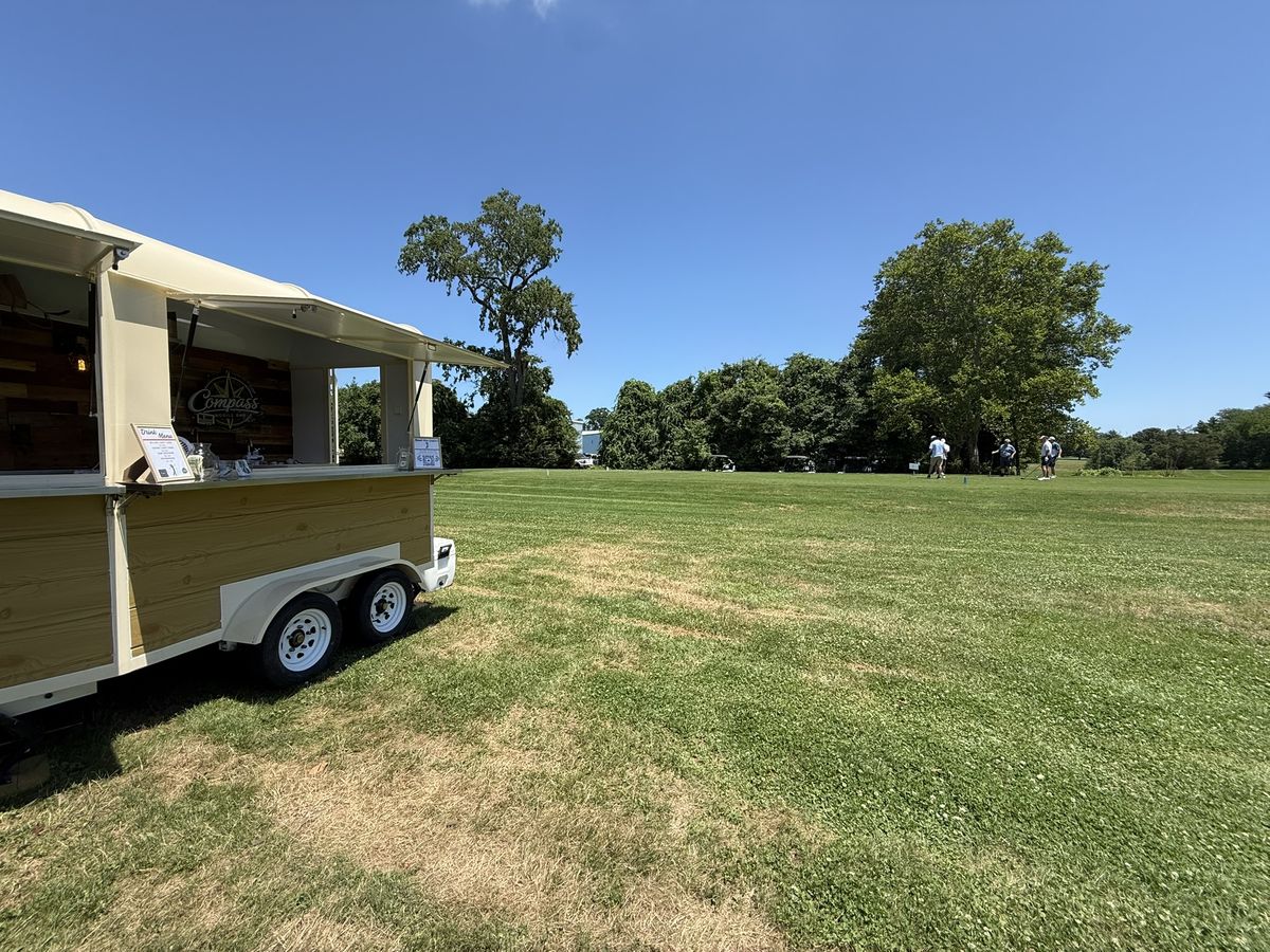 The Compass trailer set up along the fairway during a golf outing