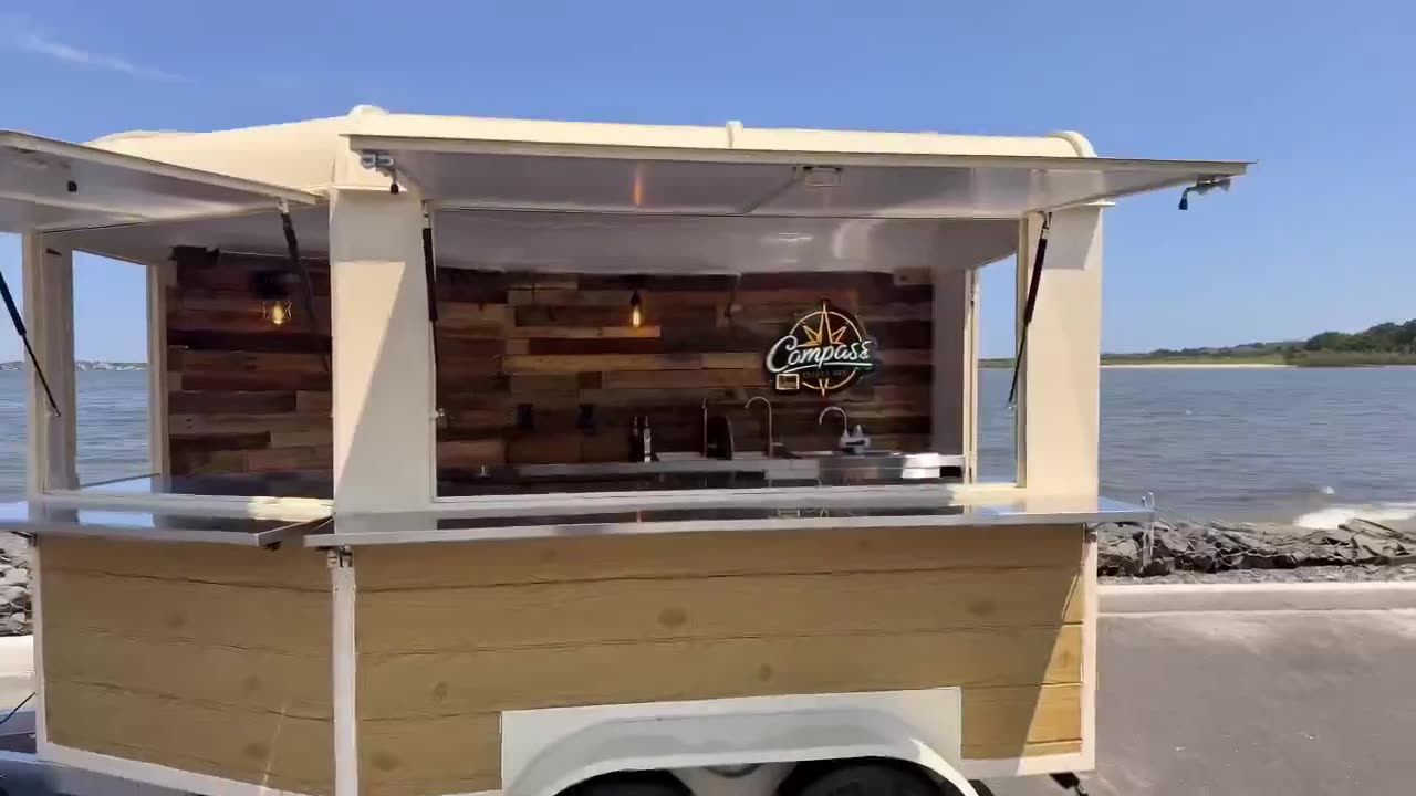 The Compass Mobile Bar trailer parked at the waterfront with its serving windows open