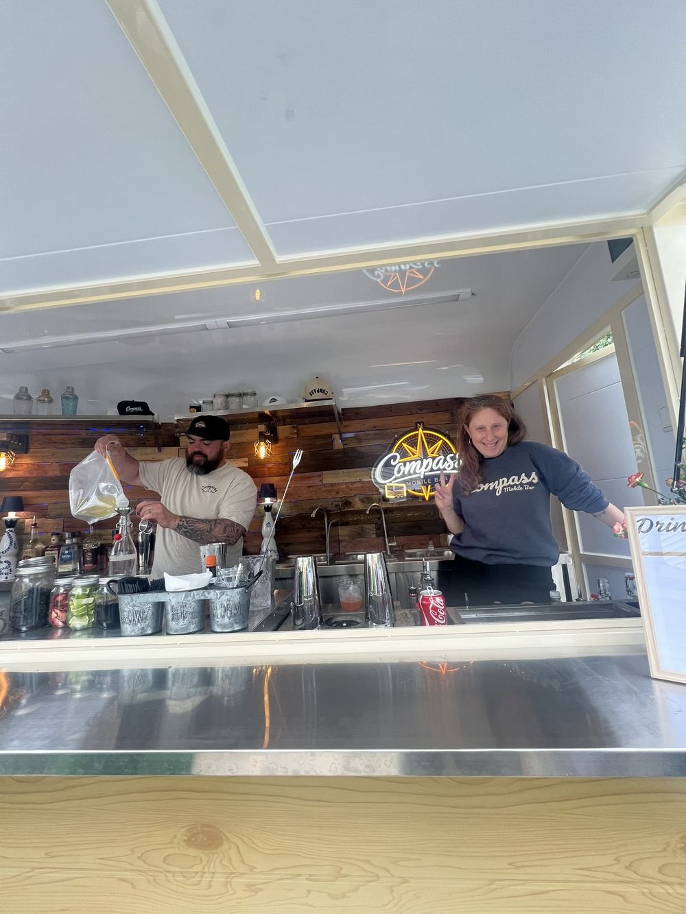 A bartender pouring a cocktail from the Compass trailer at the launch party