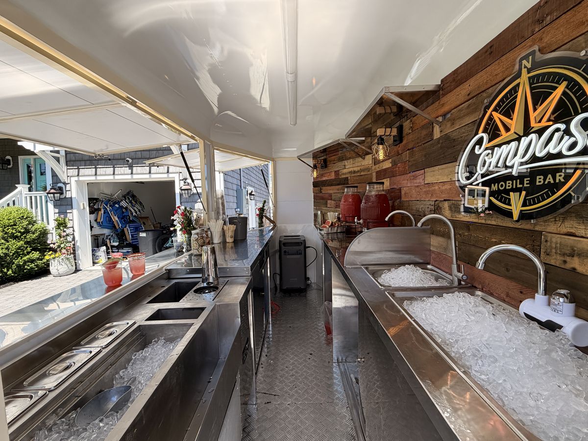 Inside the Compass Mobile Bar trailer during the Manasquan house crawl with ice wells full and juice crocks staged