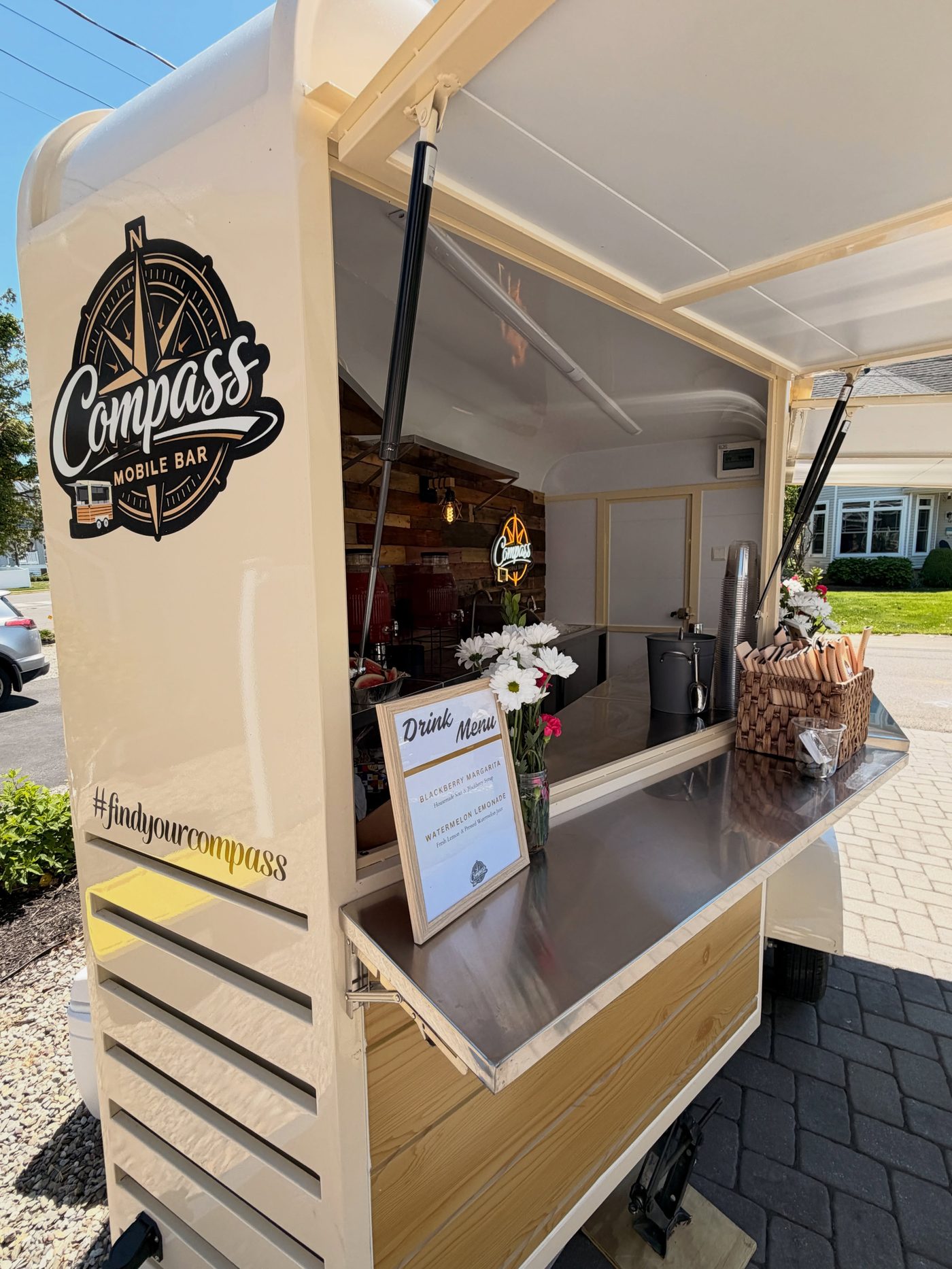 Side of the trailer with the drink menu board and fresh flowers