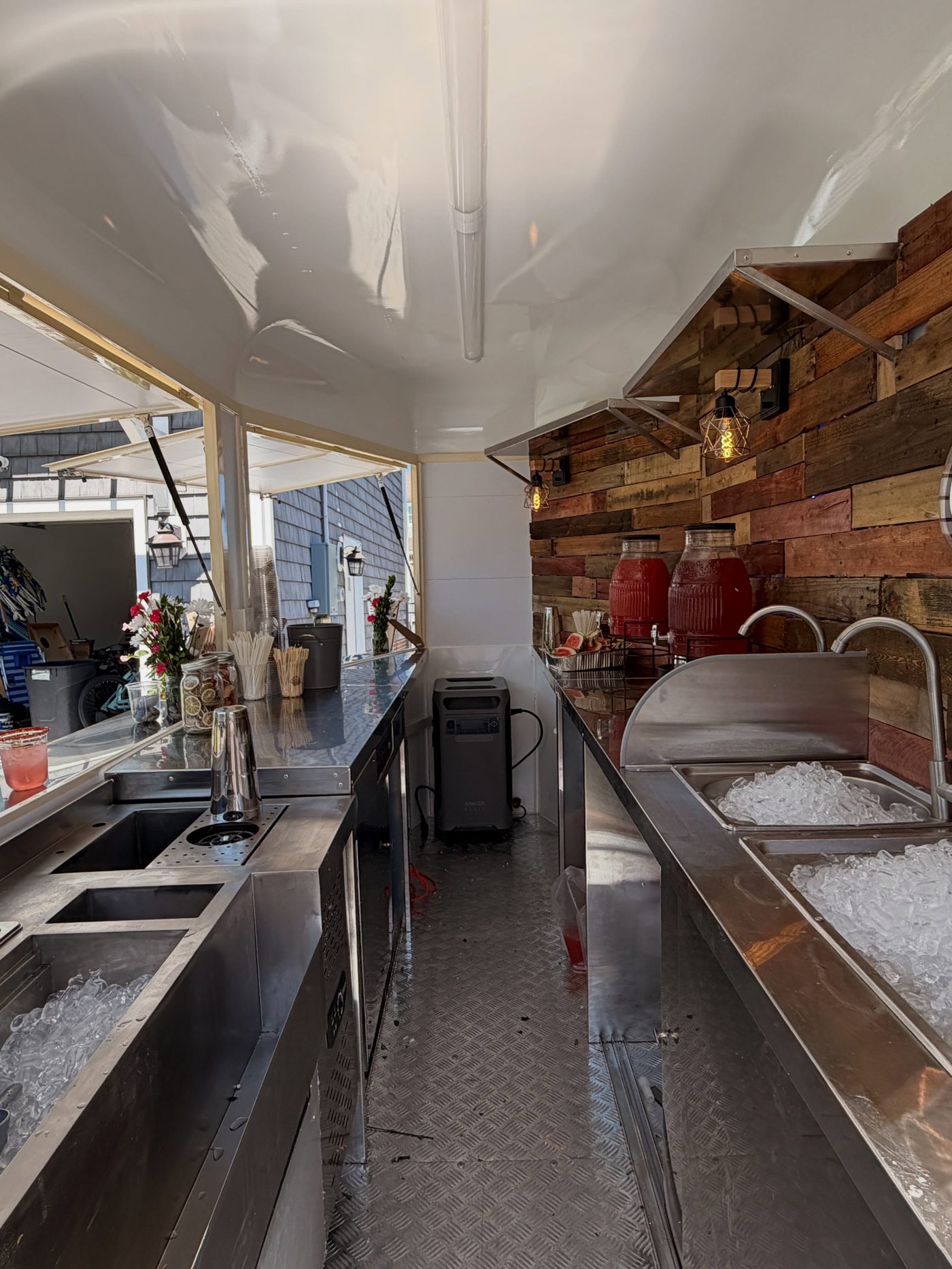 Inside the trailer, stainless steel bar stations packed with ice